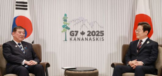 이재명 대통령이 17일(현지시간) 캐나다 앨버타주 캐내내스키스 주요 7개국(G7) 정상회의장에서 이시바 시게루 일본 총리와 한일 정상회담을 하며 일장기 앞에 앉아 있다. (사진=연합뉴스)