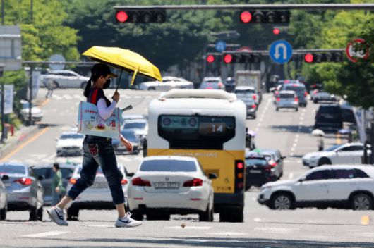 전국 대부분 지역에 폭염 특보가 발효된 지난 3일 광주 서구 치평동에서 한 시민이 강렬한 햇빛에 달구어져 아지랑이가 피어오르는 도로를 걷고 있다.(사진=연합뉴스)