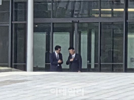 정장을 갖춰 입은 인사들이 롯데인재개발원 본관 로비 앞에서 대화를 나누고 있다. 회의 시작 시각조차 비공개로 진행된 이번 VCM은 철저한 통제 속에 열렸다. (사진=한전진 기자)