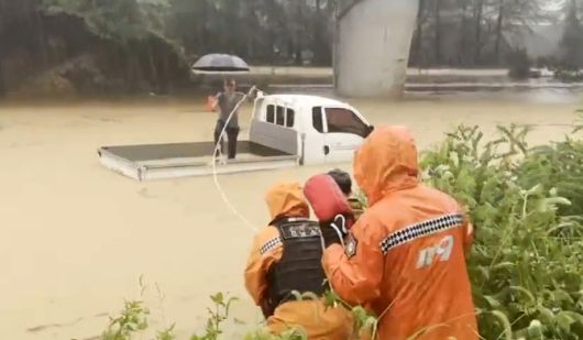 17일 경남 산청군 신안면 양지레미콘 인근 지하도가 집중호우로 침수돼 소방대원들이 트럭 위로 대피한 시민을 구조하고 있다. (경남소방본부 제공)