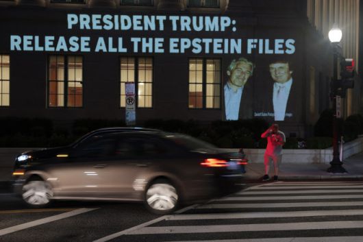 도널드 트럼프 미국 대통령과 제프리 엡스타인의 이미지, 그리고 “트럼프 대통령: 엡스타인 파일 전면 공개할 것인가?”라는 문구가 미국 상무부 본부 건물 외벽에 투사되고 있다. (사진=게티이미지)