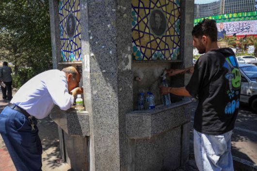 22일(현지시간) 이란 테헤란에서 폭염으로 인해 기온이 급상승한 가운데 이란인들이 공공 거리 분수대에서 물을 마시고 있다.(사진=AFP)