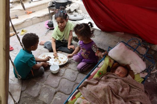 가자지구의 아이들이 음식을 나눠먹는 모습.(사진=AFP)