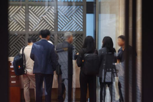 지난달 18일 김건희 여사 관련 의혹을 수사하는 민중기 특별검사팀이 압수수색을 실시한 서울 용산구 통일교 서울 본부에서 검찰 관계자들이 직원들과 대화하고 있다. 이날 특검팀은 ‘건진법사 청탁 의혹’과 관련해 가평에 위치한 통일교 본부와 서울 용산구에 있는 서울 본부에 대한 압수수색을 실시했다. (사진=연합뉴스)