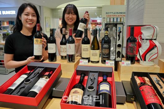 롯데마트 주류부문 상품기획자들이 보틀벙커 잠실점에서 주류 선물세트를 홍보하고 있다. (사진=롯데마트)