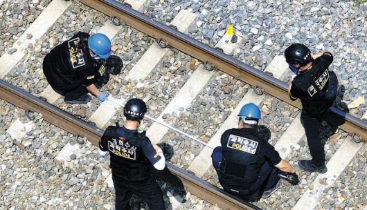 경북 청도 열차사고 합동감식팀원들이 20일 사고 지점이라고 적힌 경부선 철로에서 침목 간 거리를 재며 현장을 조사하고 있다. 합동감식반은 사고 열차 급제동과 경적 여부, 현장 작업자들의 당시 상황 등을 확인했다.(사진=연합뉴스)