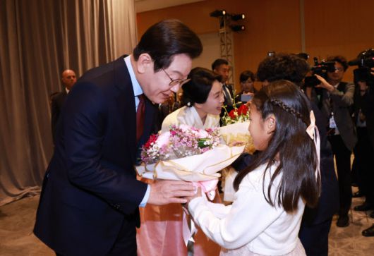 이재명 대통령과 김혜경 여사가 24일(현지시간) 미국 워싱턴DC의 한 호텔에서 열린 동포 만찬 간담회에 참석해 화동으로부터 꽃다발을 받고 있다.(사진=연합뉴스)