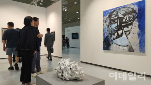 ‘프리즈 서울 2025’ 전경. 스프루스 마커스가 내건 조지 콘도의 ‘생각과 미소’(Thinking and Smiling, 2025). 관람객들의 발길을 연이어 이끈 작품이다. 180만달러(약 25억원)에 팔렸다. 아래는 로즈마리 트로켈의 조각 ‘화장지가 있어 천만다행’(Thank God for Toilet Paper, 2008)이 놓였다(사진=오현주 문화전문기자).