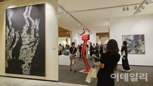 ‘프리즈 서울 2025’ 전경. 타데우스로팍이 내건 게오르그 바젤리츠의 회화 ‘프랑스의 엘케’(Elke in Frankreich Ⅲ, 2019)가 보인다. 바젤리츠의 대형회화 3점을 가져온 타데우스로팍은 그중 ‘그것은 어둡습니다, 그것은’(Es ist dunkel, es ist, 2019)을 180만유로(약 29억원)에 판매했다. 빨간 핸드백에 긴 다리를 단 에르윈 웜의 조각 ‘덧없음’(Vanity, 2023)은 관람객의 시선을 집중시킨 작품 중 하나다(사진=오현주 문화전문기자).