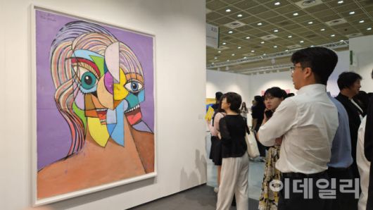 ‘프리즈 서울 2025’ 전경. 한 관람객이 조지 콘도의 ‘퍼플 선샤인’(Purple Shunshine, 2025)을 오래도록 지켜봤다. 하우저앤워스 부스에 걸린 이 작품은 120만달러(약 16억 7000만원)에 판매됐다(사진=오현주 문화전문기자).