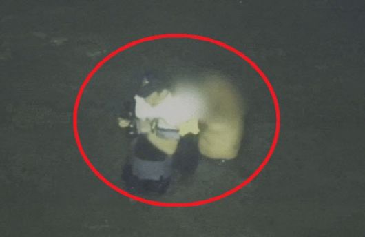 이재석 경사가 11일 오전 3시께 꽃섬 인근 갯벌에서 고립된 중국인에게 구명조끼를 벗어주고 있다. (사진=인천해양경찰서 제공)