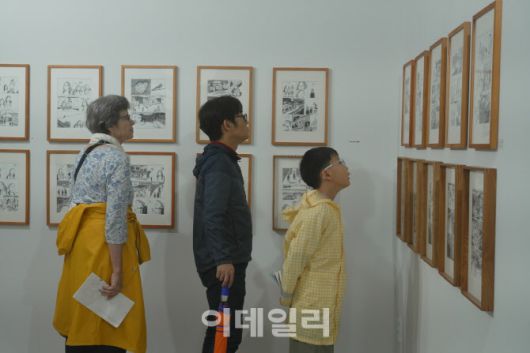 태백 장성마을 주민들이 아이리스PC방 건물 지하에 전시된 전지 작가의 ‘불확실한 내 이야기를 들어줄 한 사람이 필요해’ 만화 원화를 관람하고 있다. (사진=탄탄마을협동조합)