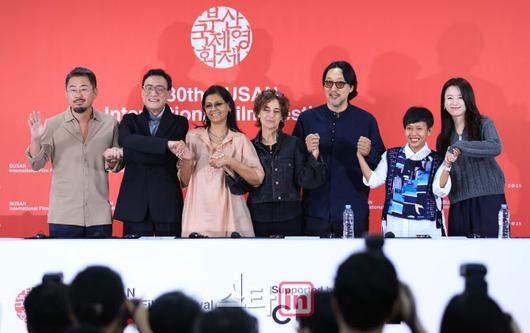 [이데일리 스타in 노진환 기자] 제30회 부산국제영화제 경쟁 심사위원 기자회견이 18일 부산 해운대구 우동 영화의전당에서 열렸다. 나홍진 감독(왼쪽부터), 배우 양가휘, 감독 겸 배우 난디타 다스, 마르지예 메쉬키니 감독, 코고나다 감독, 율리아 에비나 바하라 프로듀서, 배우 한효주가 손을 맞잡고 인사하고 있다.