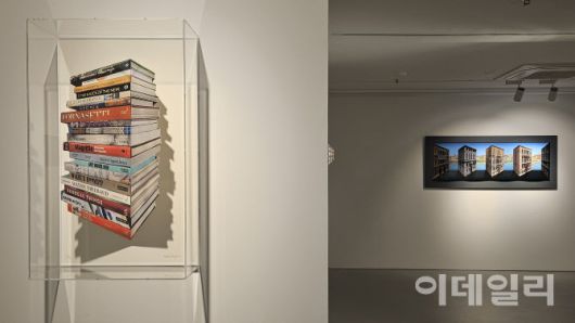 서울 용산구 소월로 박여숙화랑 ‘패트릭 휴즈 개인전’ 전경. 왼쪽에 패트릭 휴즈의 ‘서가’(Bookstack 2025, Ed.15/50, 76.3×46.2×22.4㎝)가 걸렸다. 뒤쪽으로 ‘가장한 팔라조’(Pretend Palazzo 2025, 70.3×172.7×20㎝, edition of 5+2APs)가 보인다(사진=오현주 문화전문기자).