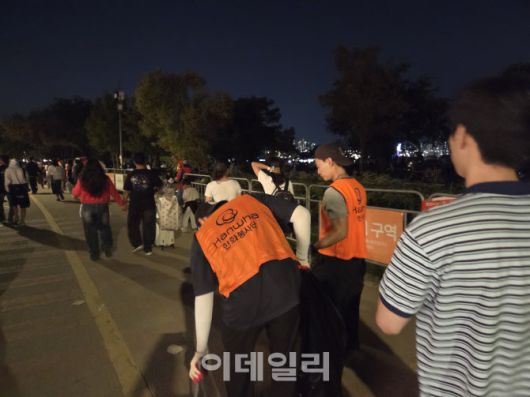 27일 오후 ‘서울세계불꽃축제 2025’가 끝난 뒤 한화 봉사단이 쓰레기를 줍고 있다. (사진=염정인 수습기자)