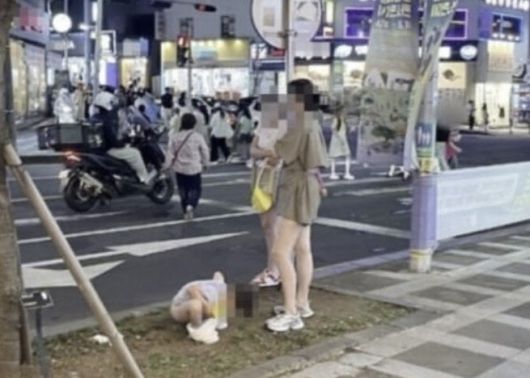 지난해 6월 제주시 연동의 한 인도 화단에서 용변을 보는 아이를 제지하지 않는 중국인 관광객의 모습. (사진=온라인 커뮤니티 캡처)