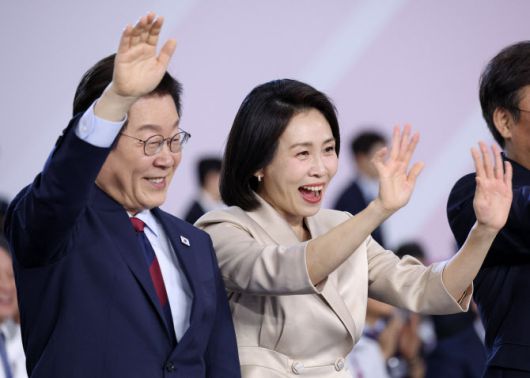 이재명 대통령과 김혜경 여사가 17일 부산아시아드주경기장에서 열린 전국체전 개막식에서 입장하는 선수단을 향해 손을 흔들고 있다.(사진=연합뉴스)