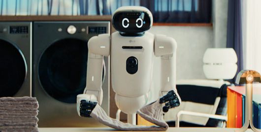 세탁실로 보이는 공간에서 흰색 휴머노이드 로봇 클로이드가 양손으로 양말을 들고 있다. 로봇 전면에는 카메라 센서가 장착돼 있으며, 얼굴 부분에는 눈 모양의 디지털 디스플레이가 표시돼 있다. 사진=최은수 인텔리빅스 대표