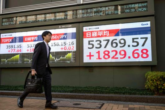 13일 일본 도쿄 도쿄증권거래소에서 닛케이 주가지수 수치를 표시한 전광판 앞을 한 남성이 지나가고 있다. (사진=AFP)