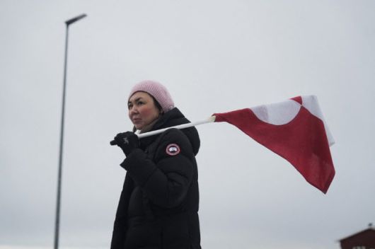 17일(현지시간) 그린란드 누크에서 미국 대통령의 그린란드 인수 계획에 반대하는 시위가 열리는 가운데, 한 여성이 그린란드 국기를 들고 있다. (사진=AFP)