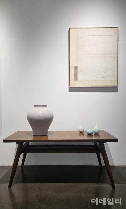 갤러리조은 ‘평온의 가장자리’ 전 전경. 작가 성연화의 작품과 조우한 조원재의 작품들이 2인전의 특별한 풍경을 만들어내고 있다. 탁자 위에 설치한 조원재의 작품 ‘분홍빛 호’(2023, 30×30×33㎝·왼쪽)와 ‘매우 작은 순간의 가장자리’(2025) 연작 위로 성연화의 한지회화 ‘평온’(Serenity 2025)이 걸렸다(사진=오현주 문화전문기자).