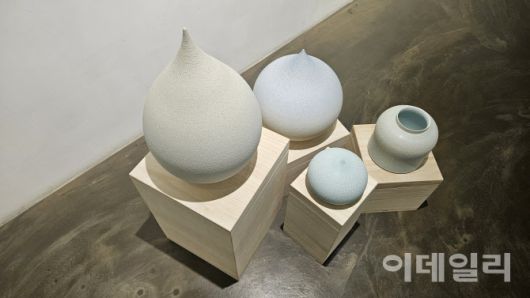갤러리조은 ‘평온의 가장자리’ 전 전경. 바닥에 설치한 조원재의 ‘물방울’ 연작과 항아리 작품을 위에서 내려다봤다. ‘순간의 가장자리’(2025), ‘푸른 물방울’(2025) 곁에 ‘2023-푸른호-017’(2023, 21×21×20㎝·오른쪽)가 놓였다(사진=오현주 문화전문기자).