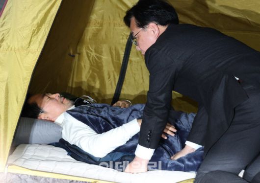 [이데일리 노진환 기자] 통일교 및 공천헌금 특검 수용을 촉구하며 8일째 단식을 이어가고 있는 장동혁 국민의힘 대표가 22일 서울 여의도 국회 로텐더홀 농성장에 마련된 텐트 안에 누워 있다. 송언석 원내대표가 최고위원회의 시작 전 장 대표를 찾아 보고 있다.