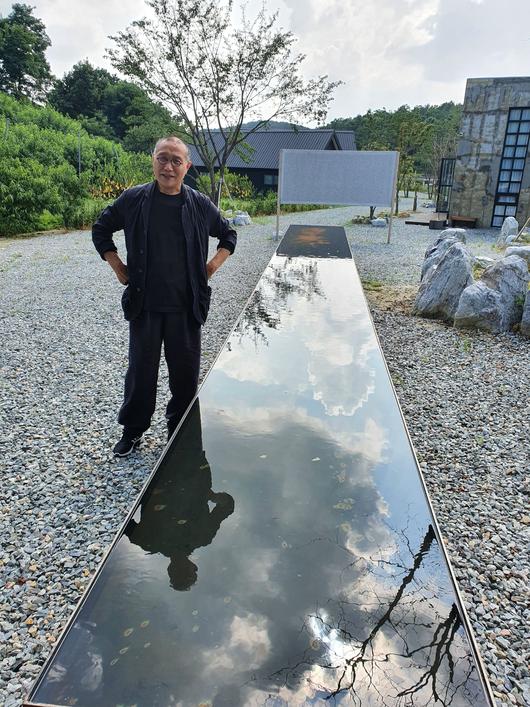 김아타 작가의 경기 여주 개인미술관인 '아르테논'. 작가 뒤로 보이는 캔버스가 자연 상태에서 2년 동안 걸어놓아 자연이 스스로 흔적을 남기게 만든 작품. /김한수 기자
