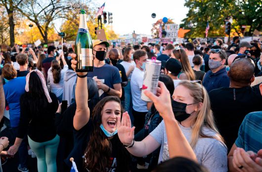 현지시각 7일 조 바이든 후보의 당선이 언론을 통해 발표되자 워싱턴 DC 시민들이 거리로 쏟아져 나와 샴페인을 터뜨리며 축하 하고있다./AFP 연합뉴스