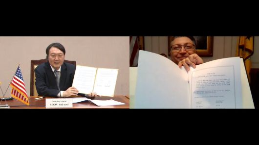 윤석열 검찰총장이 18일 미국 연방검찰(DOJ)과 화상회의를 통해 진행된 '한미 검찰 반독점 형사집행 MOU 체결식'에서 협약서를 들어보이고 있다