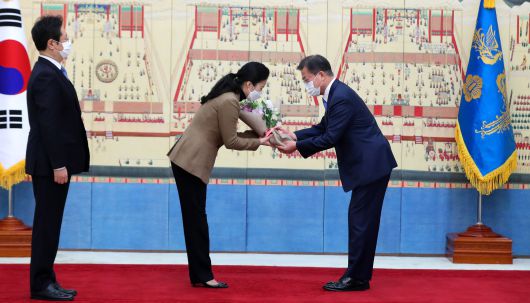 문재인 대통령이 15일 청와대에서 황희 문화체육관광부 장관에게 임명장을 수여하고 황 장관의 부인에게 꽃다발을 전하고 있다. /연합뉴스