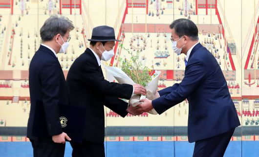문재인 대통령이 15일 청와대에서 권칠승 중소벤처기업부 장관에게 임명장을 수여하고 함께 참석한 권 장관의 아버지에게 꽃다발을 전달하고 있다. /연합뉴스