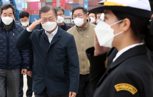 문재인 대통령이 25일 가덕도 공항 예정지 선상 시찰을 마치고 부산신항 다목적부두에 위치한 해양대학교 실습선으로 이동하며 해양대 학생들의 경례를 받고 있다. 2021.2.25/연합뉴스