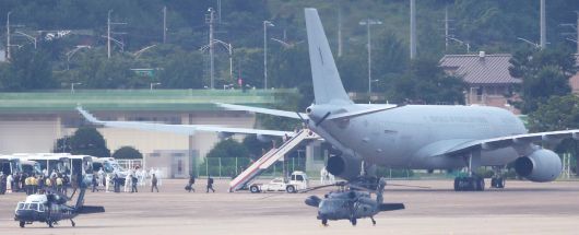 7월 20일 오후 공군 다목적 공중급유수송기(KC-330)로 서울공항에 도착한 청해부대 34진 문무대왕함(4천400t급)의 장병들이 방역 관계자들의 안내를 받아 치료-격리시설로 향하는 버스로 이동하고 있다./연합뉴스
