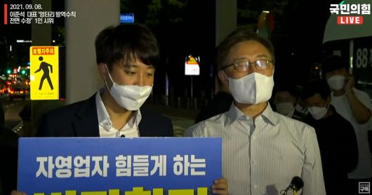 여의도에서 각각 1인 시위를 하다 우연히 만난 이준석 대표와 최재형 후보. 최 후보가 발언하는 사이 이 대표가 유튜브 라이브를 보러 들어온 사람들의 실시간 채팅을 확인하고 있다. /국민의힘 유튜브 채널 '오른소리'