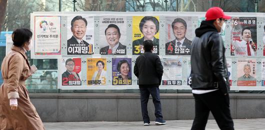제20대 대통령 선거 사전 투표를 하루 앞둔 3일 오후 서울 종각옆 앞에서 유권자들이 후보들의 선거벽보를 살펴보고 있다./뉴스1