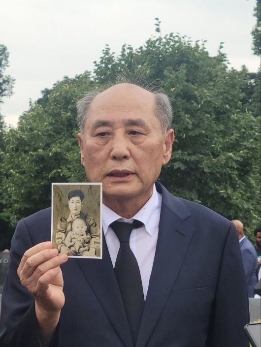 워싱턴DC 한국전 참전 기념공원 내에 건립된 추모의 벽 앞에서 26일(현지 시각) 카투사로 참전했다가 전사한 고(故) 한상순씨의 아들 한신희씨가 어린 시절 선친과 찍은 사진을 들어 보이고 있다. /워싱턴=김진명 특파원