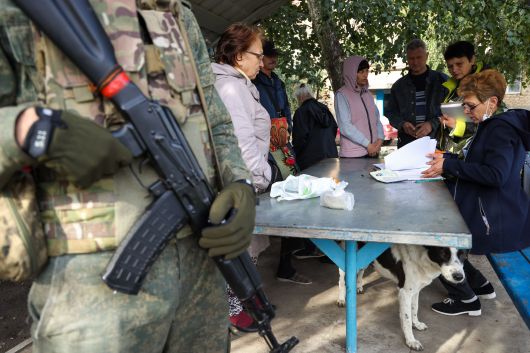 24일(현지 시각) 우크라이나 도네츠크인민공화국(DPR)에서 우크라이나 내 러시아 점령지의 러시아 합병에 대한 투표가 이뤄지고 있는 가운데, 총을 든 병사가 주변을 지키고 있다./타스통신 연합뉴스