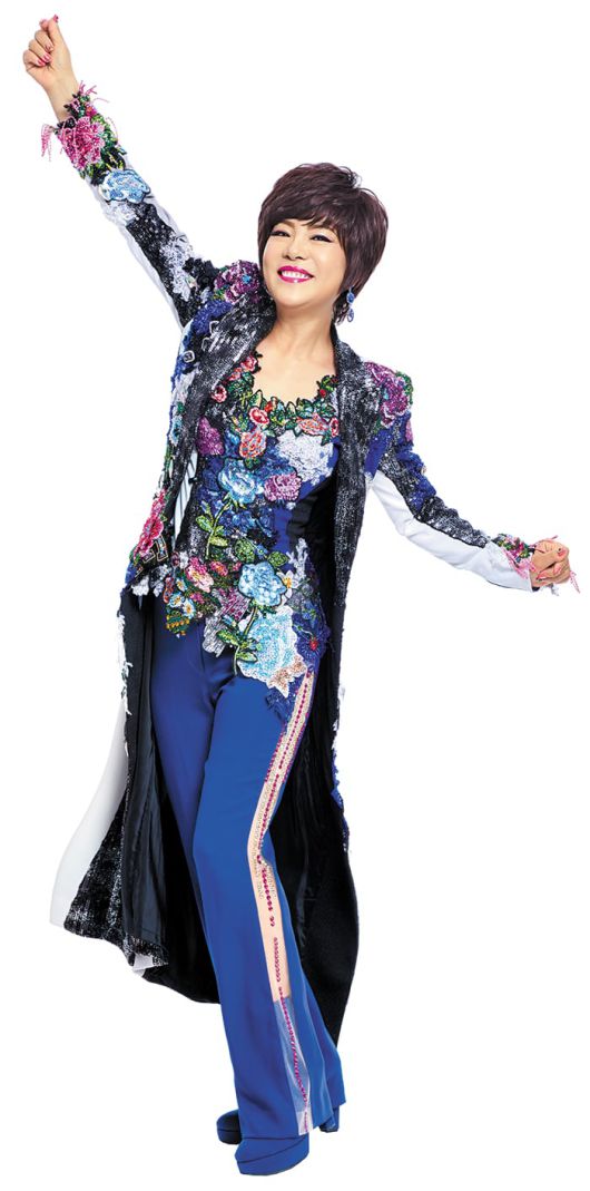 화려한 바지 정장과 쇼트 가발을 착용한 김연자가 포즈를 취하고 있다. 데뷔 이후 줄곧 그의 옷에 수놓인 꽃무늬가 환하게 빛났다. /상연기획
