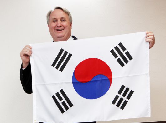 2012년 3월 21일 오후 경기도 과천 법무부청사에서 인요한(53·미국명 존 린튼) 박사가 권재진 법무장관으로부터 대한민국 국적 증서를 받고, 태극기를 들어보이고 있다. 자신의 공로로 특별귀화자가 된 것은 인 소장이 처음이다./이태경 기자