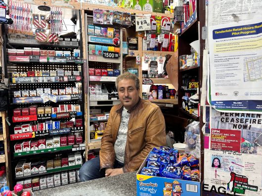 지난 22일 샌프란시스코 텐더로인에서 가게를 운영하고 있는 알리 마나(48)씨 위로 'USA'라는 장식물이 걸려있다. 가게 계산대 앞에는 시(市)에서 배포한 '텐더로인 영업 시간 규제 파일럿 프로그램'의 안내문이 붙어 있었다. 마나씨는 "이 구역에서 가게 여러개를 운영하는데, 야간 영업 규제에 걸리는 가게는 매출 감소가 심각할 것"이라며 "샌프란시스코는 당장 마약과 범죄 문제를 해결할 사람이 필요하고, 그건 트럼프라고 생각한다"고 했다. /오로라 특파원