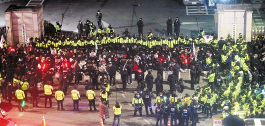 尹 지지자·경찰, 서부지법 앞 대치 - 17일 저녁 윤석열 대통령을 지지하는 시위대가 서울 마포구 서울서부지법 앞에서 경찰과 대치하고 있다. 이날 고위공직자범죄수사처는 서부지법에 윤 대통령에 대한 구속영장을 청구했다. /연합뉴스