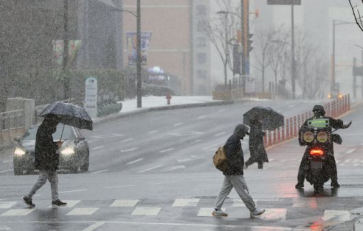 설 명절 연휴 사흘째이자 대설특보가 발효된 27일 오전 서울 성동구 거리를 지나는 우산을 쓴 시민들이 발걸음을 재촉하고 있다. /뉴스1