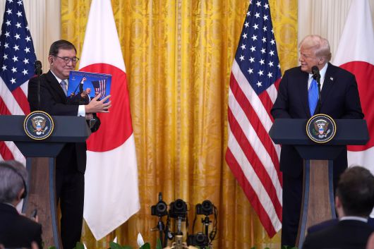 이시바 시게루 일본 총리(왼쪽)가 지난 2월 7일 미국 워싱턴DC 백악관에서 가진 도널드 트럼프 미국 대통령과의 공동기자회견에서 트럼프 대통령이 선물한 사진집을 들어보이고 있다./AP 연합뉴스