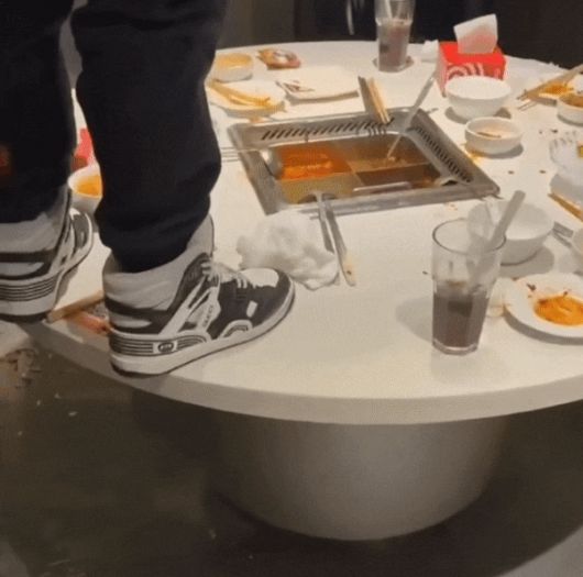 한 중국 남성이 상하이의 훠궈 전문점 하이디라오에서 테이블에 올라가 소변을 보고 있다. /웨이보