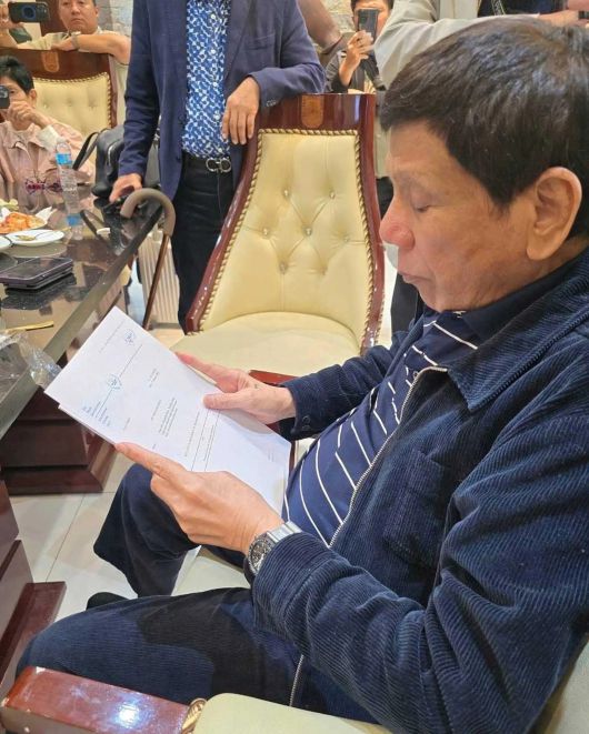 두테르테 전 대통령이 헤이그로 압송되기에 앞서, ICC가 발부한 체포 영장을 보고 있다.