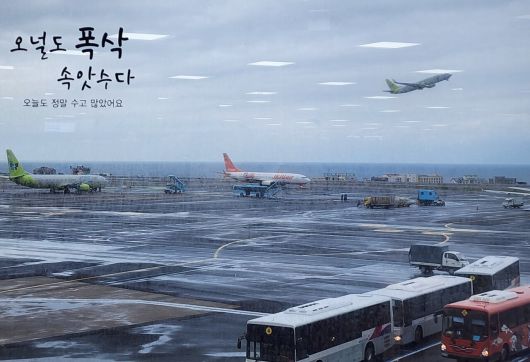 지금은 사라진 제주 공항 국내선 유리창의 '오널도 폭삭 속앗수다(‘오늘도 수고 많으셨습니다’ 의미의 제주 방언)' 문구.