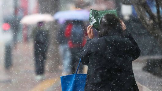 강풍을 동반한 눈비가 갑작스럽게 내린 13일 오후 서울 중구 덕수궁 인근에서 시민들이 발걸음을 재촉하고 있다. /박성원 기자