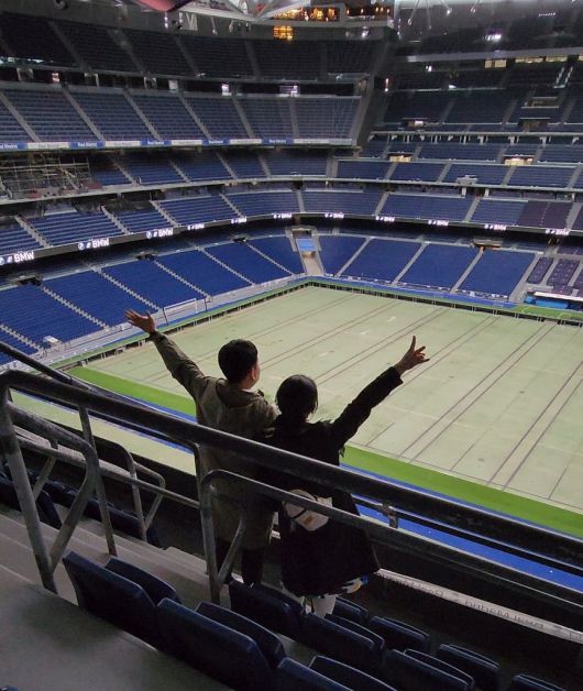 Kim Hyun-seok (left) and Park Go-eun pose at Estadio Santiago Bernabéu in Madrid, Spain, last March, in this photo provided by Park. The couple skipped a traditional wedding ceremony and instead chose a honeymoon across Europe, visiting the home stadium of Spanish football club Real Madrid.
