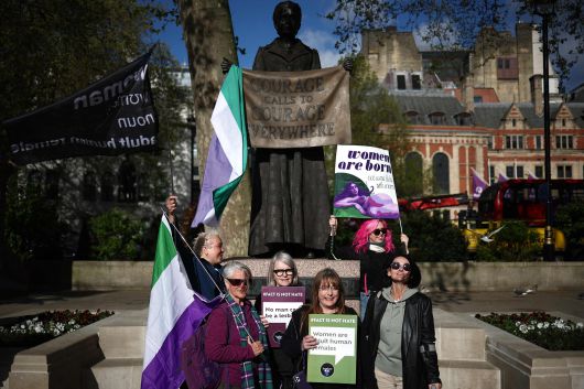 16일 영국 런던 대법원 건너편 국회의사당 광장에서 열린 일부 여성 활동가들이 '여성은 정해지는 것이 아니라 태어나는 것'이라고 적힌 플래카드를 들고 있다. /AFP 연합뉴스